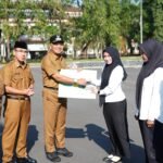 Wakil Bupati Tasikmalaya menyerahkan jaminan sosial ketenagakerjaan usai Apel pagi di halaman Gedung Bupati Senin 21 September 2026.