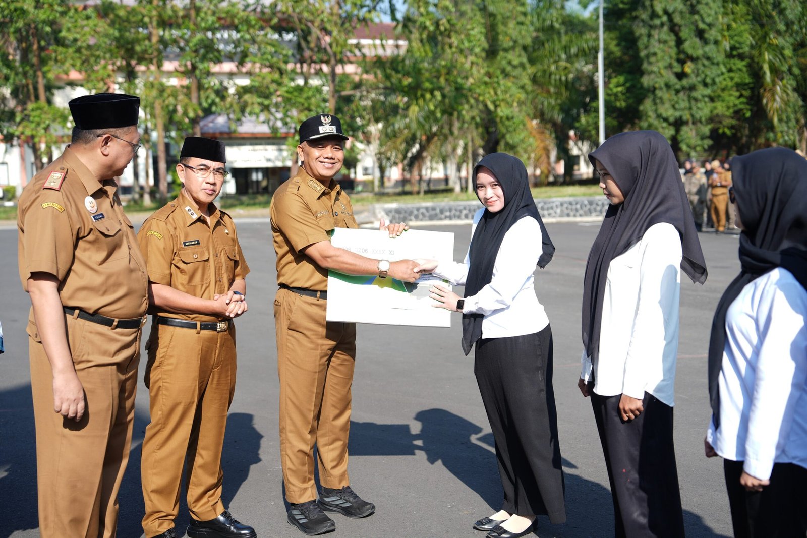 Wakil Bupati Tasikmalaya menyerahkan jaminan sosial ketenagakerjaan usai Apel pagi di halaman Gedung Bupati Senin 21 September 2026.